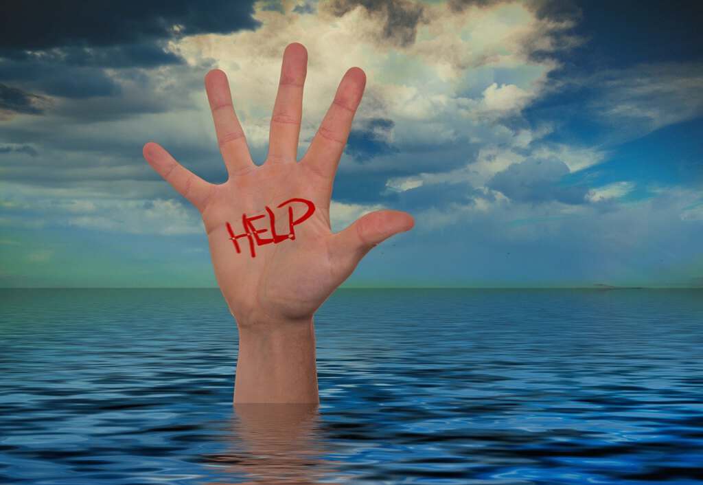 Eine Hand mit der Aufschrift "Help" streckt sich aus Wasser empor.