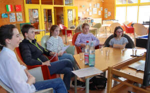 Fünf Personen sitzen am Tisch